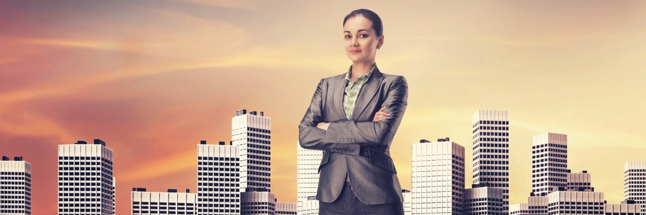 businesswoman standing among skyscrapers