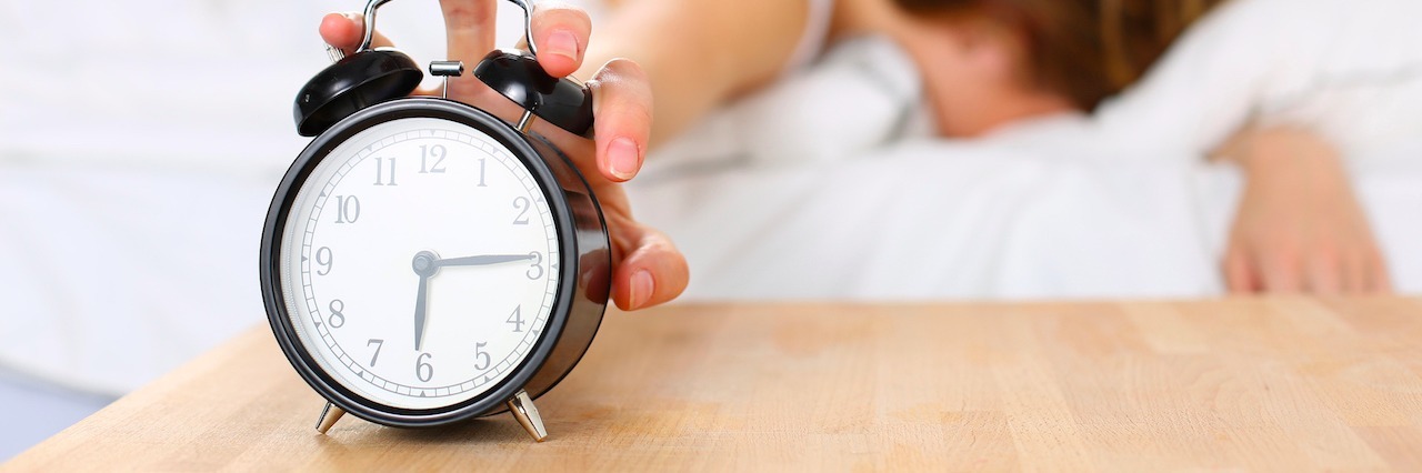 A Timeline of My Depression A woman touching her alarm clock