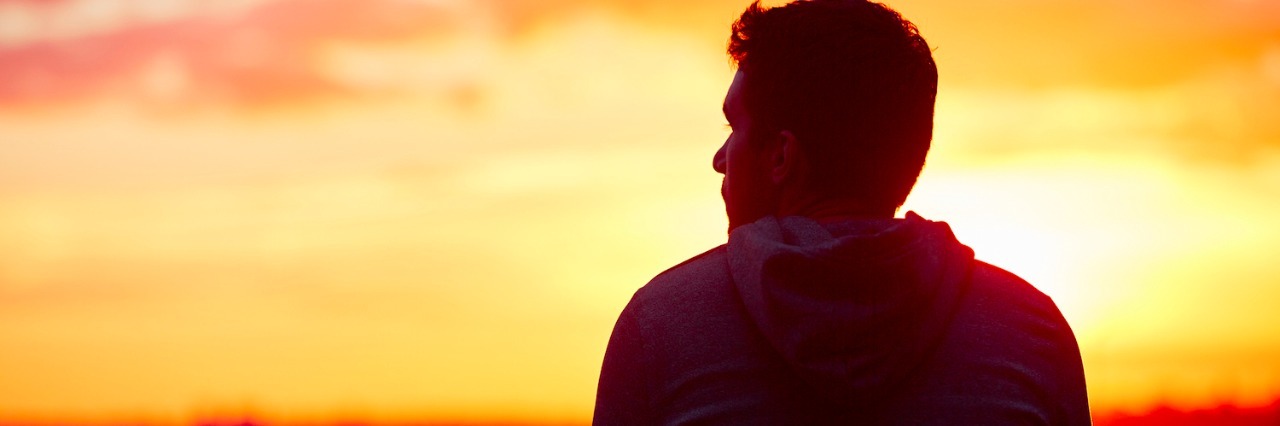 Man in front of sunrise landscape