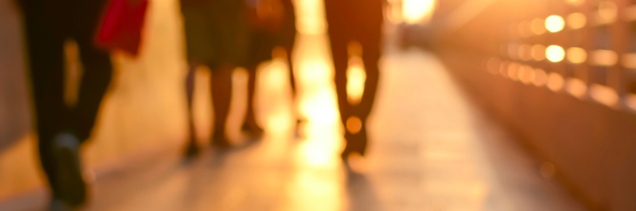 Blur silhouette of people walking on walkway in twilight
