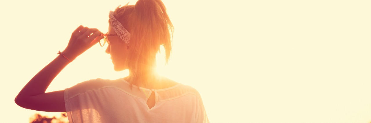 How 'Always Wanting More' Gets Me Through Chronic Health Conditions woman looking ahead with sun rising