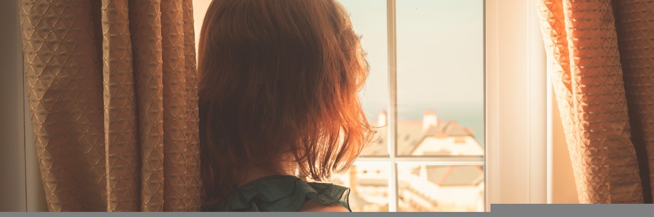 What I Mean When I Say 'I Am Functioning' as a Person With Illness woman looking out the window