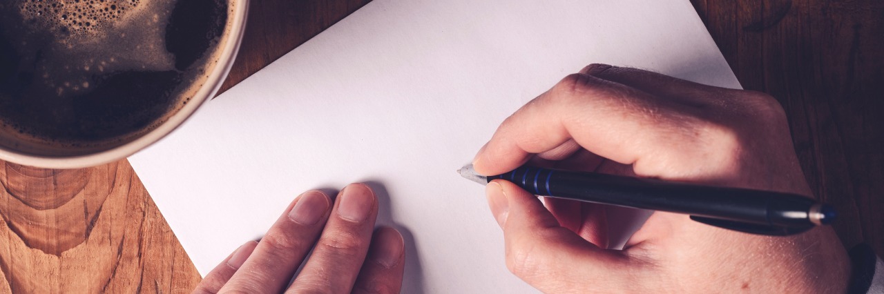 5 Things You Should Know When You're Diagnosed With a Chronic Illness A woman writing a note, with a cup of coffee by her side.