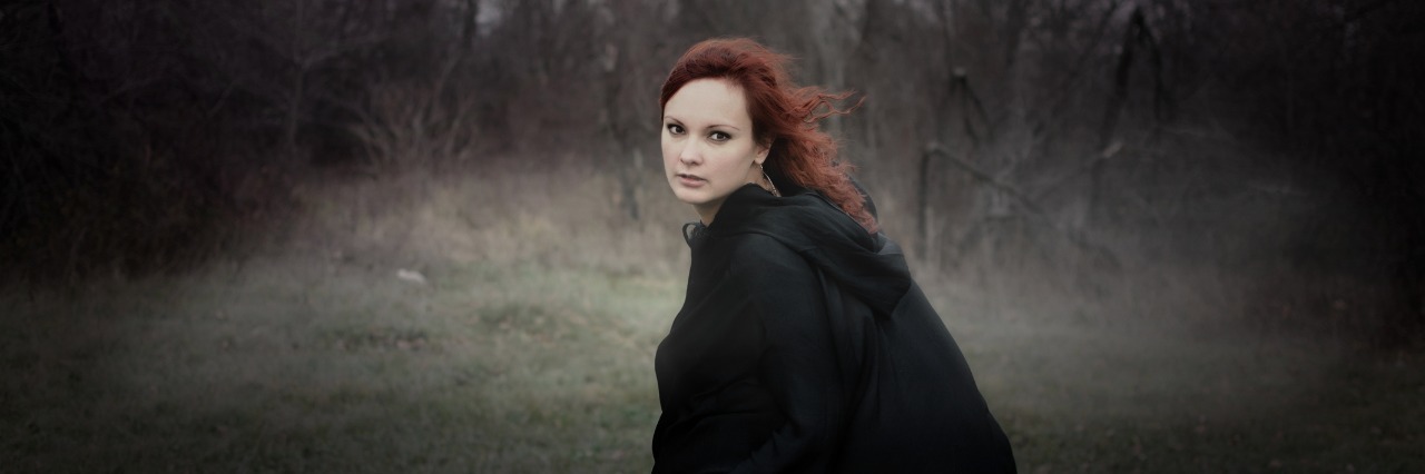 How I Channeled My Chronic Illness Grief Into Something Good Woman looking at camera at night.