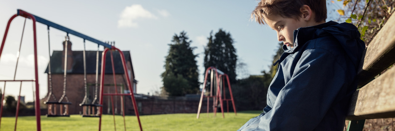 Kids and Ehlers-Danlos Syndrome – How to Avoid Being Left Out Lonely child sitting on playground bench.