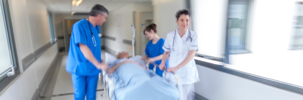 How Chronic Illness Can Lead to Anxiety emergency room staff wheeling a patient down a hallway on a gurney