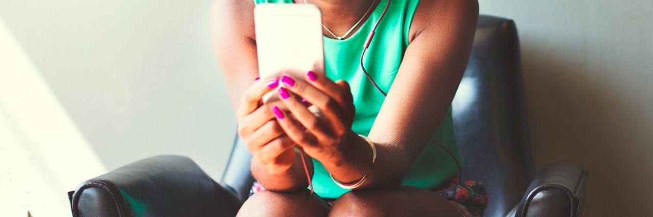 Why I Post About My Illness on Instagram Instead of Facebook woman typing on phone