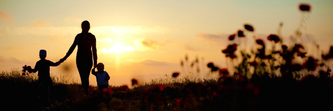 Requests for Autism Awareness Month From the Mom of Autistic Children Mom holding hands with two children near a grassy area at sunset