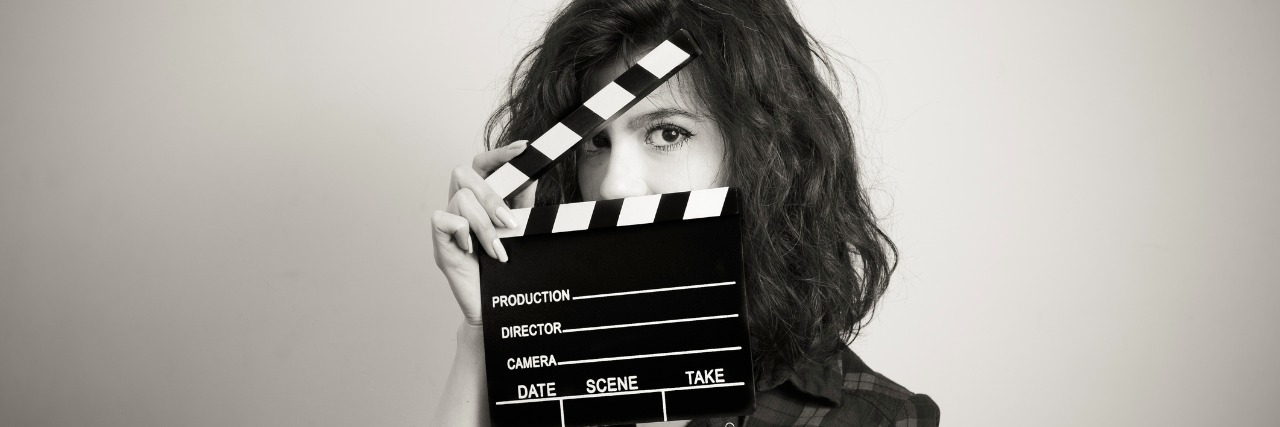 Depression Forces Me to Wear a Mask and Act OK Woman actress eyes portrait behind movie clapper board vintage black and white
