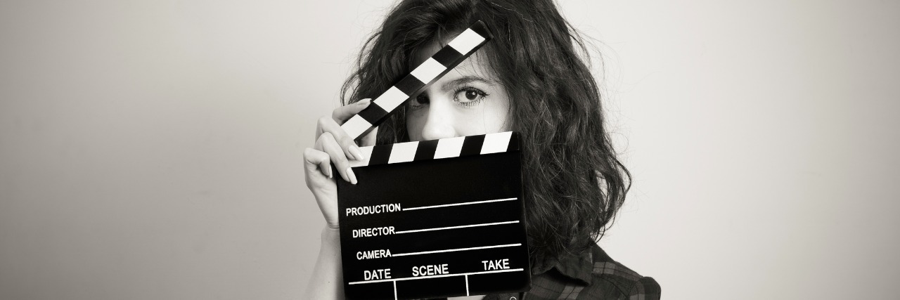 Woman actress eyes portrait behind movie clapper board vintage black and white
