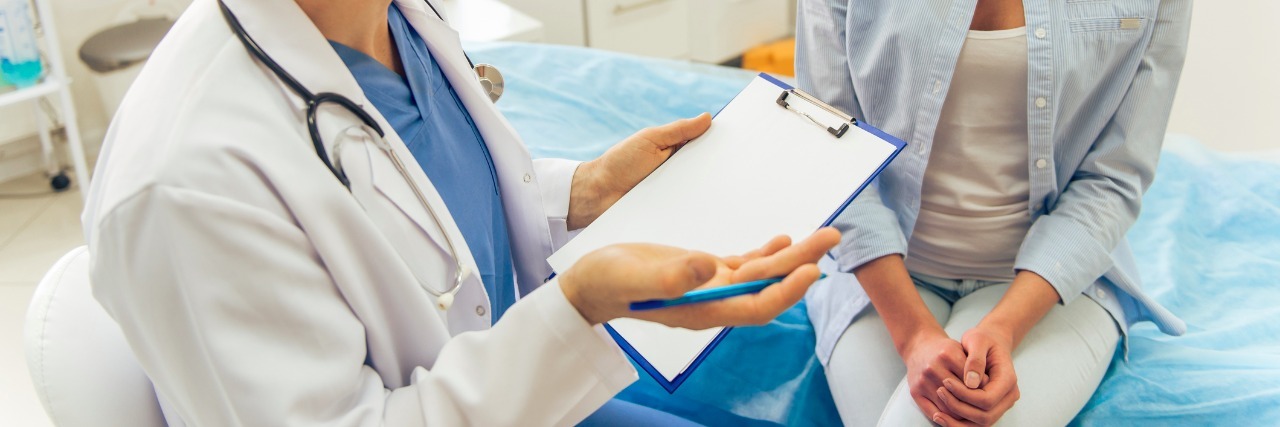 Why Doctors Shouldn't Joke About Patients Who Use Internet to Diagnose doctor is talking with patient and making notes while sitting in his office