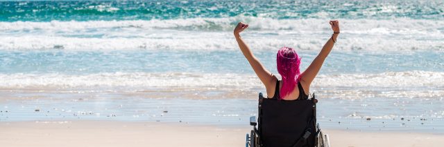 Disabled woman in a wheelchair at the beach.