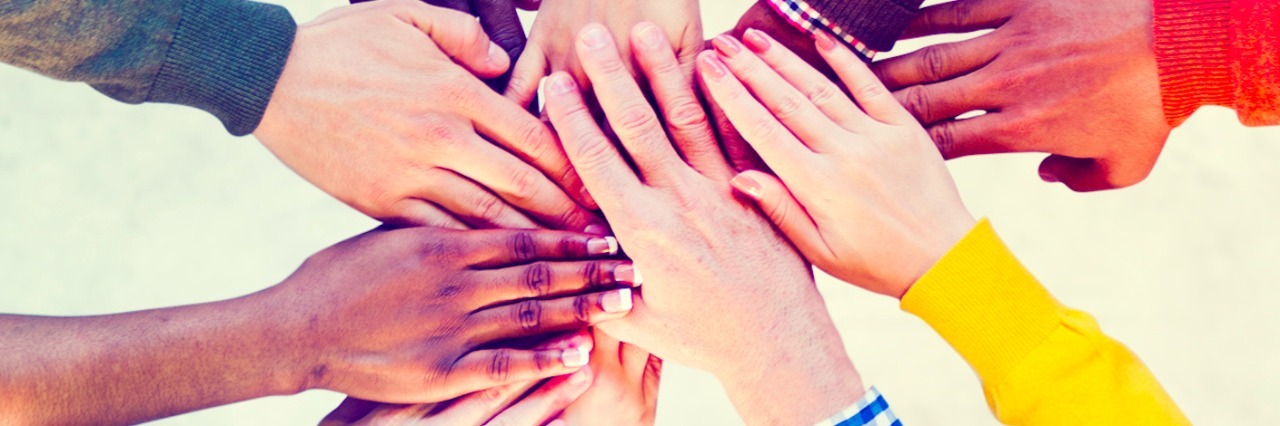 Group of people with hands stacked on top of each other