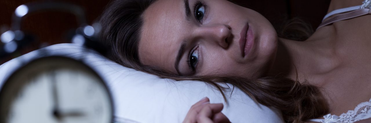 Woman lying in bed suffering from insomnia