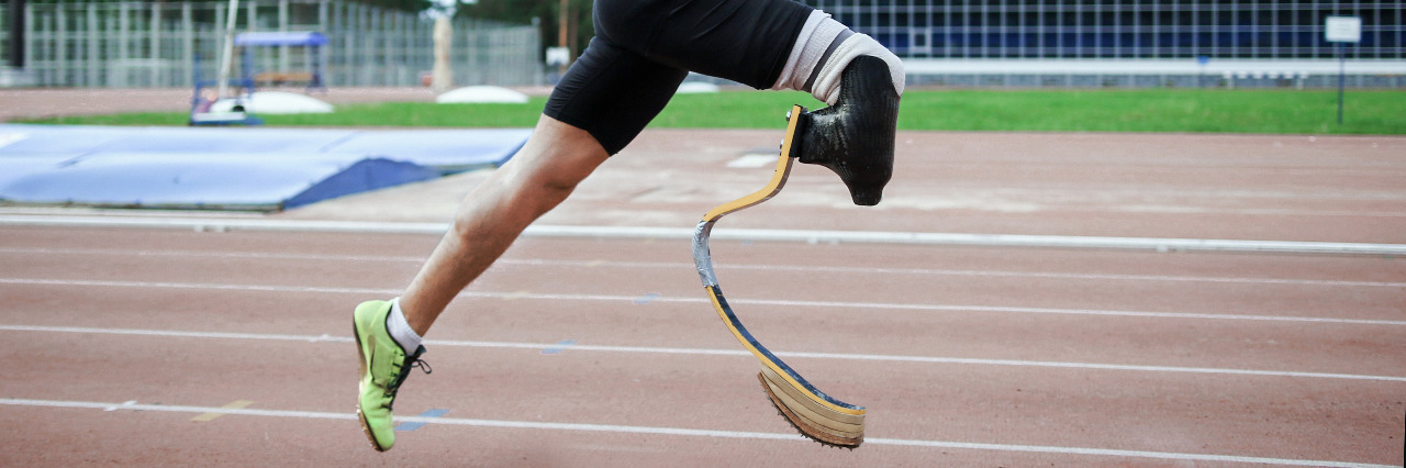Athlete with prosthetic leg running.