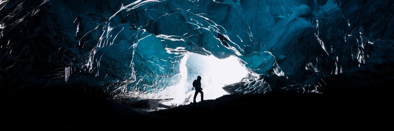 When Mental Illness Is Like Feeling Trapped in a Dark Cave man exploring glacial cave in iceland