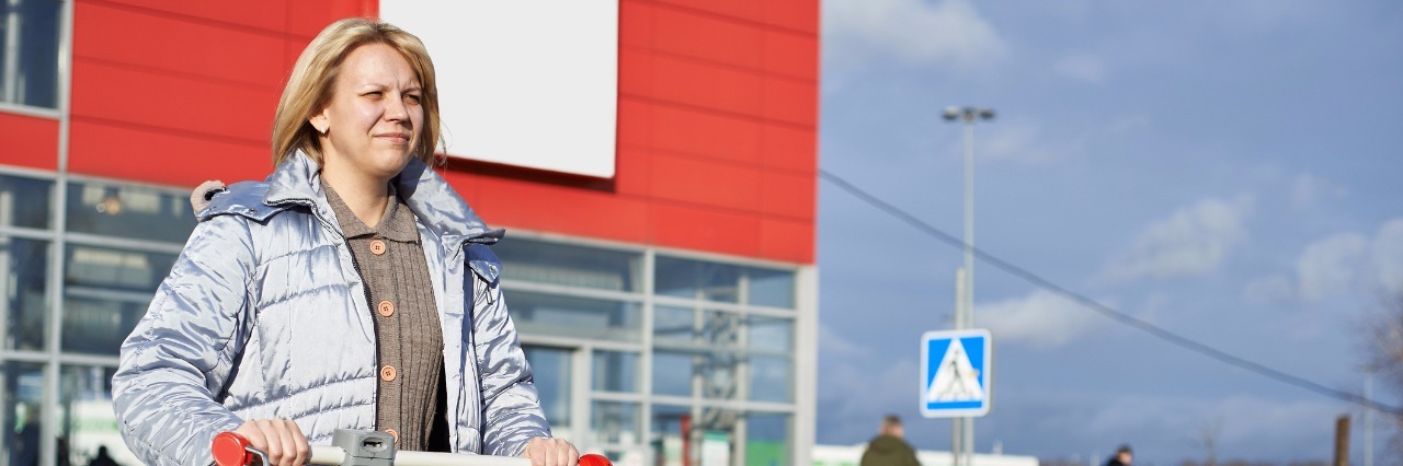 Fibromyalgia: Telling Strangers to 'Smile' woman pushing shopping cart through parking lot and frowning