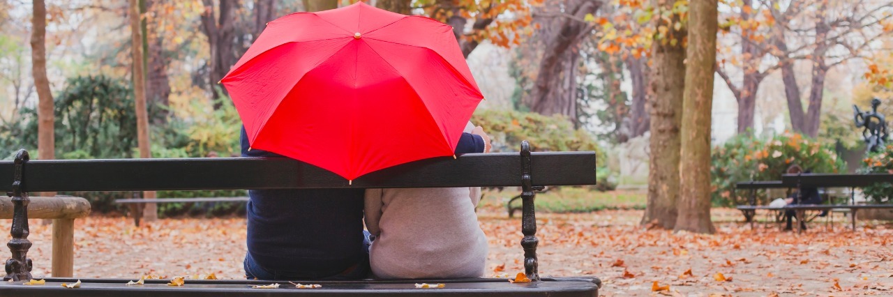 couple under umbrella in autumn park