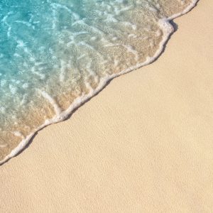 Soft wave of blue ocean on sandy beach, background