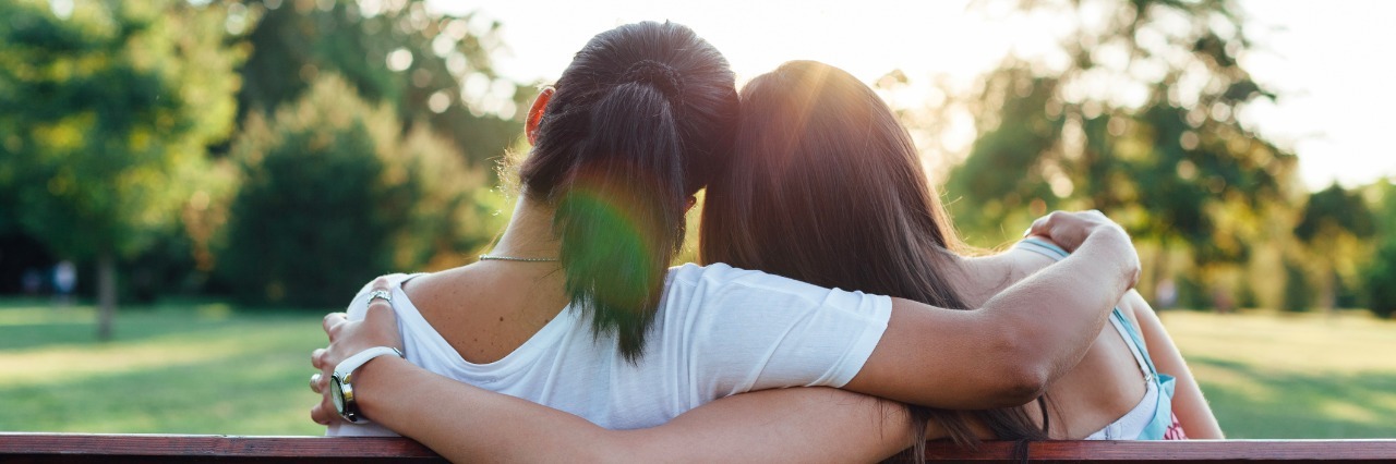 25 Ways to be a Good Friend to Someone with Dysautonomia two women with arms around each other on bench
