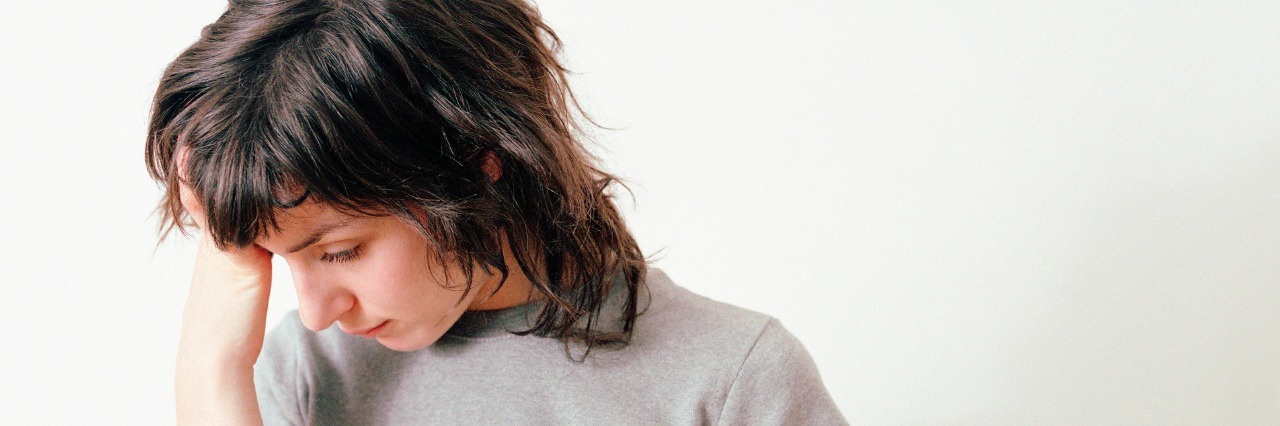 The Struggles of the Idiopathic Hypersomnia Sleepy Life Tired woman holds hand to her head.