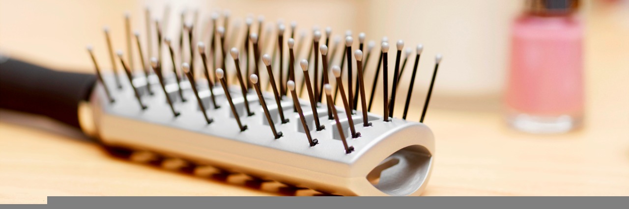What It's Like Losing Hair Due to Lupus in Your 20s hair brush on table with makeup