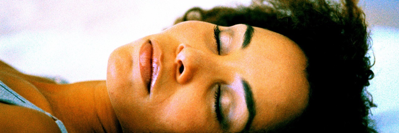 Close-up shot of the face of a young woman sleeping on a bed
