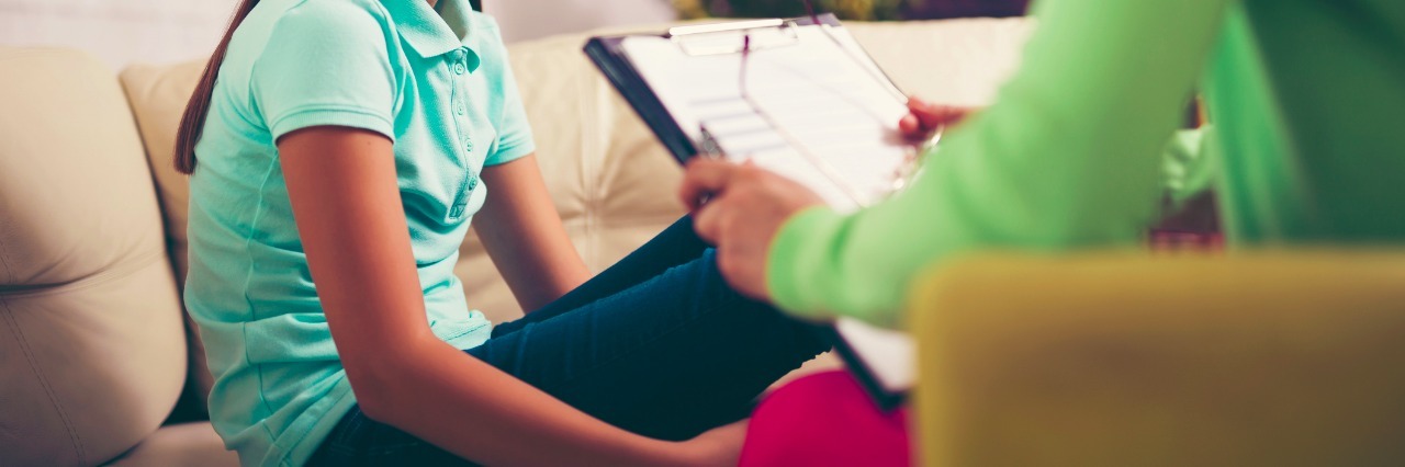 What It Was Like Seeing a Lyme Disease Specialist for the First Time woman sitting on couch with doctor holding clipboard