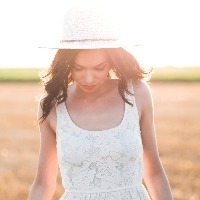 Portrait of beautiful young woman with hat in the field