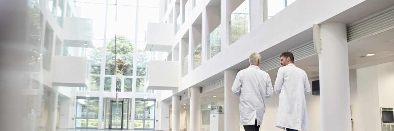 I Switched Primary Care Doctors for My Mental Health Rear View Of Doctors Talking As They Walk Through Hospital