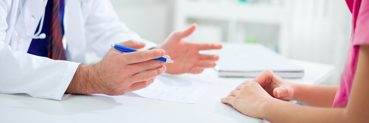 My Experience Receiving a De Quervain's Tenosynovitis Diagnosis Doctor having a conversation with patient at desk