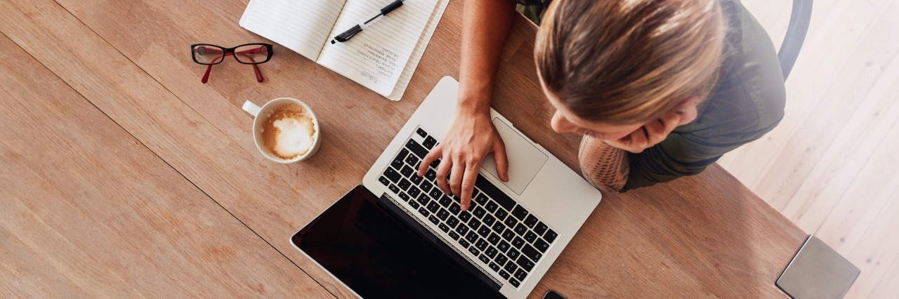 Posting Online to Raise Awareness of Lyme Disease bird's eye view of a woman sitting at a table and typing on her laptop