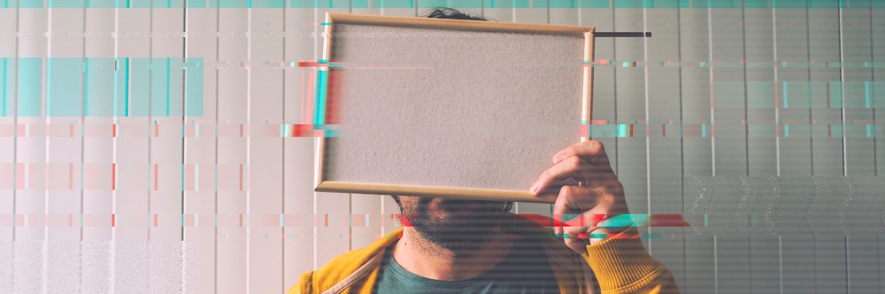 What It Feels Like to Have a 'Depression Hangover' A man holding a blank picture frame over his face