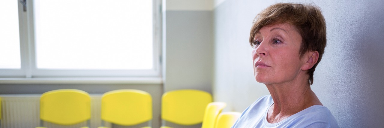 Losing a Loved One While Living With Chronic Pain Older woman sitting in hospital waiting room.