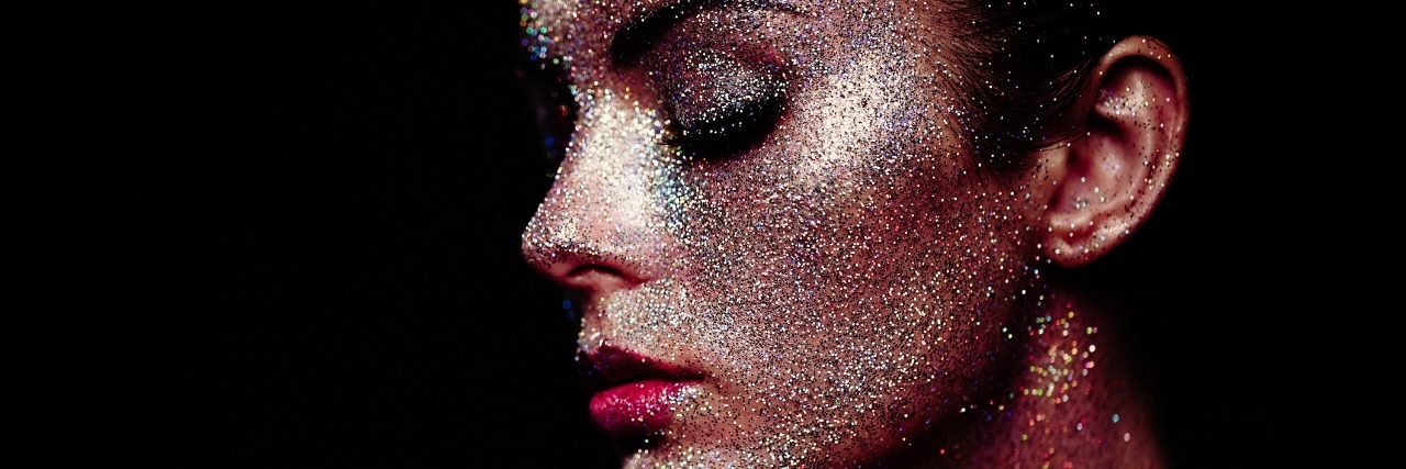 Portrait of beautiful woman with sparkles on her face.