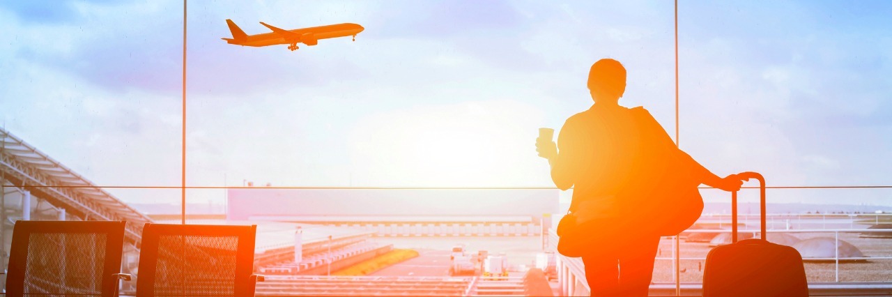 When I Traveled to the U.S. With Ulcerative Colitis silhouette of traveler with suitcase waiting in airport