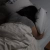woman lying facedown on bed