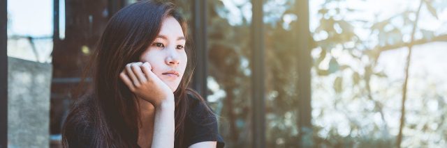 young woman sitting at cafe contemplating depressed
