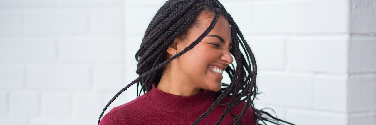 I Want to Hear What Makes You a Mental Health Warrior A woman closing her eyes and smiling, tossing her hair