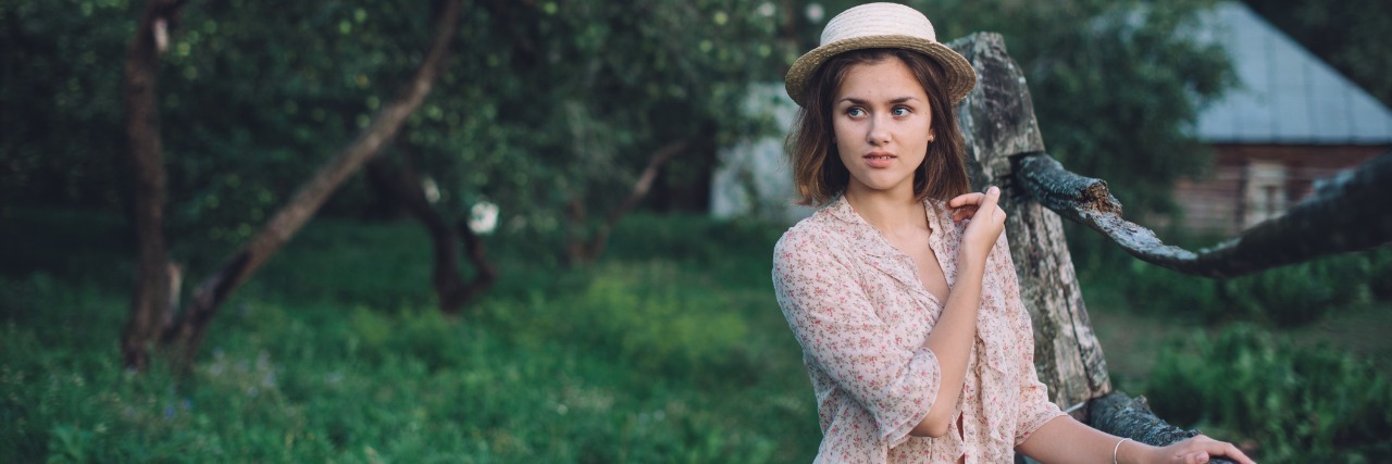 Isolation: The Unspoken Side Effect of Chronic Migraine Girl stands outside alone.