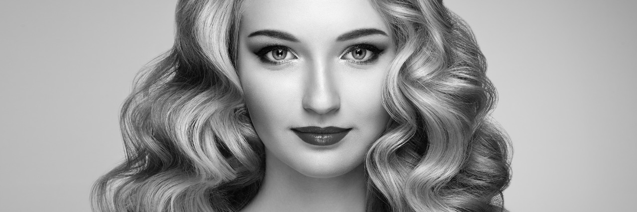 Why I'm Relieved to Have a Lupus Flare Black and white image of a woman with curly hair, slight smile.