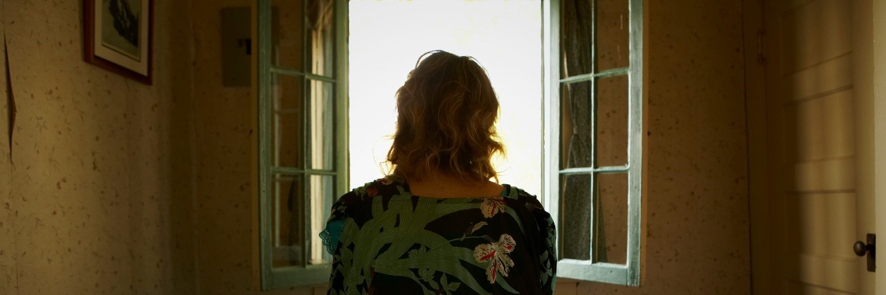 What It's Like to Be Functional and Have Lyme Disease woman sitting on her bed and looking out the window