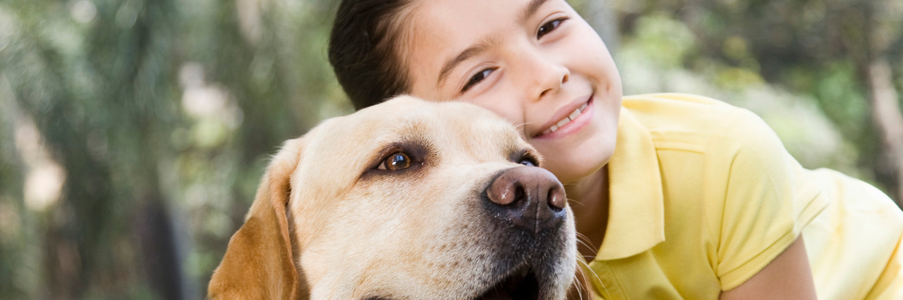 Girl hugging dog.