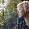 A woman looking out the window at trees