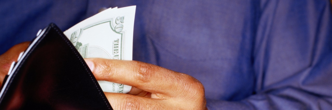 Healing From Compulsive Spending in Bipolar Disorder Recovery Man Taking Money out of Wallet