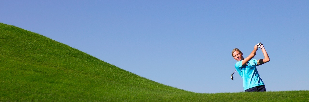 Woman swinging at golf course