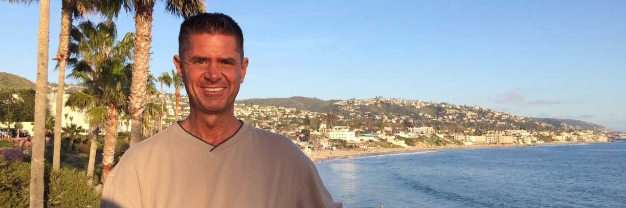 Dystonia: Accepting Your Illness, Not Feeling Like a Victim man posing in front of laguna beach
