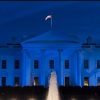 Photo of the White House lit blue.
