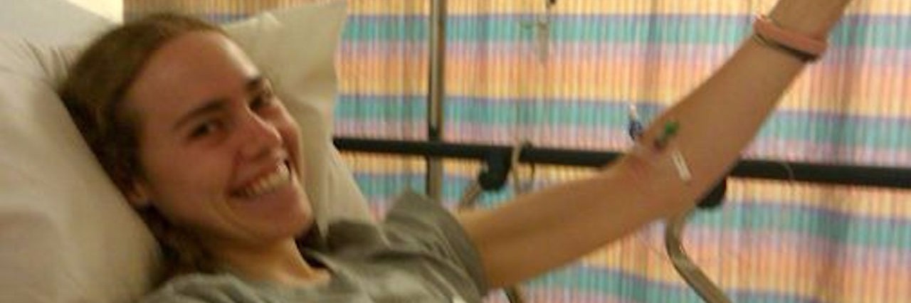 Gastroparesis, POTS, Colonic Inertia: Fighting Mystery Illnesses young woman smiling in hospital bed with tubes attached to her arm