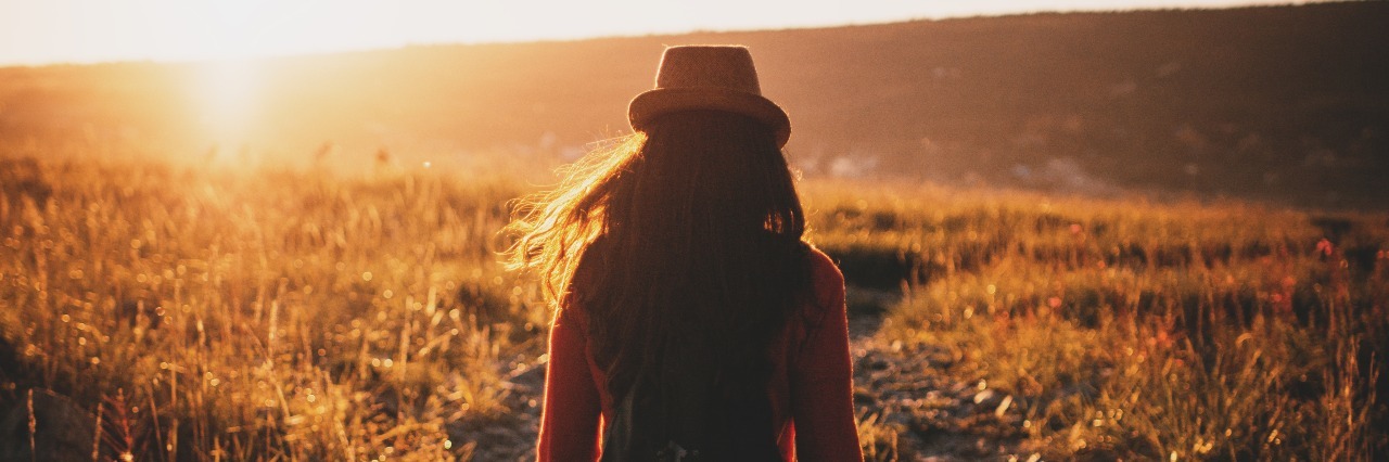 Why I'm Never Going Back to My Eating Disorder Woman walking through field at sunset